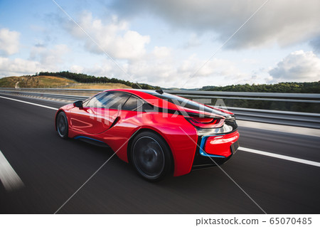 Red sport car with black autotuning speed drive on the autobahn  65070485