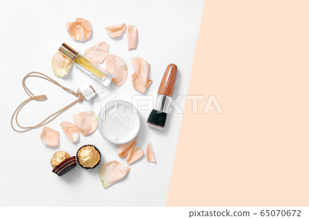 Perfume bottles with flowers petals on light 65070672