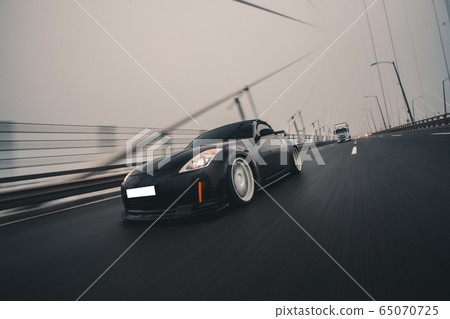 Black sport car on the highway in a foggy weather Black sport car on the highway in a foggy weather 65070725