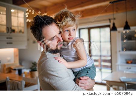 Father with small sick unhappy son indoors at home, comforting him. 65070942