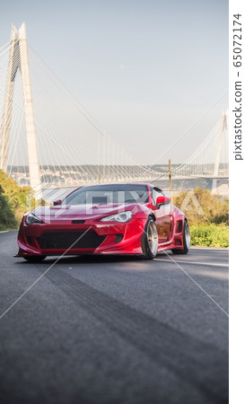 Superpower red racing car on the top of the hill 65072174