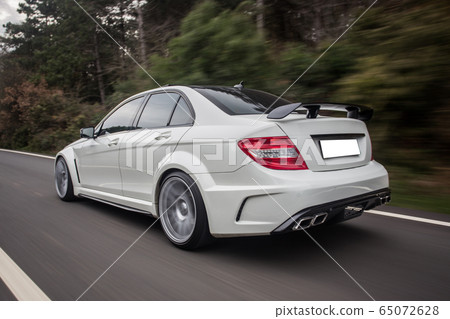 White sedan with red lights on the forest road White sedan with red lights on the forest road 65072628