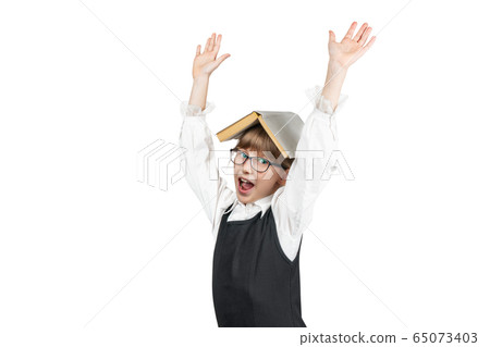 Schoolgirl with a book on her head 65073403