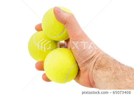 three tennis balls in a male hand three tennis balls in a male hand 65073408
