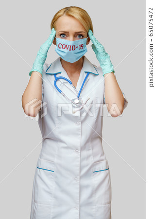 medical doctor nurse woman wearing protective mask and rubber or latex gloves - headache and stress 65075472