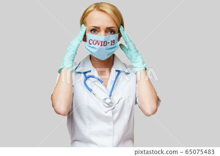 medical doctor nurse woman wearing protective mask and rubber or latex gloves - headache and stress 65075483