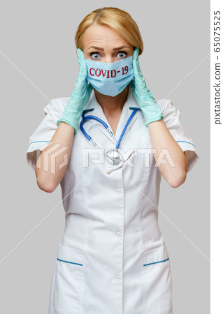 medical doctor nurse woman wearing protective mask and rubber or latex gloves - headache and stress 65075525