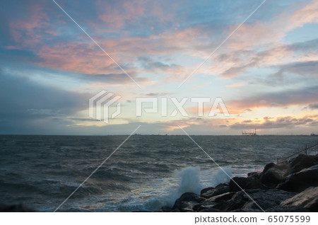 Dramatic splashing ocean wave in the evening Dramatic splashing ocean wave in the evening 65075599