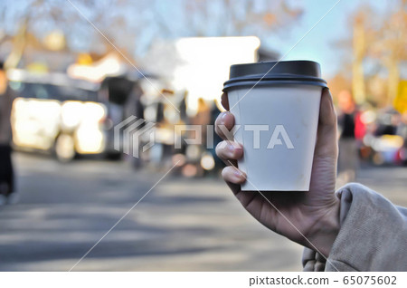 Take away white paper hot coffee cup with right hand 65075602