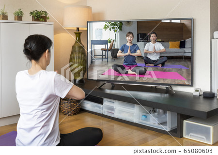 Webinar Online yoga seminar Woman doing yoga while watching DVD Webinar Online yoga seminar Woman doing yoga while watching DVD 65080603