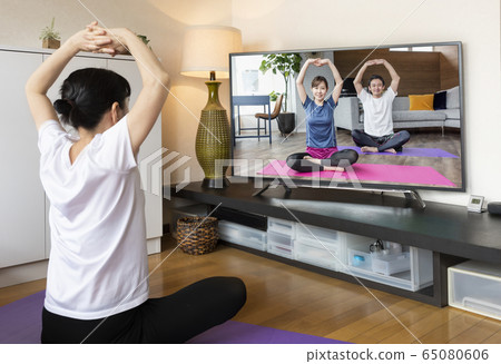 Webinar Online yoga seminar Woman doing yoga while watching DVD 65080606