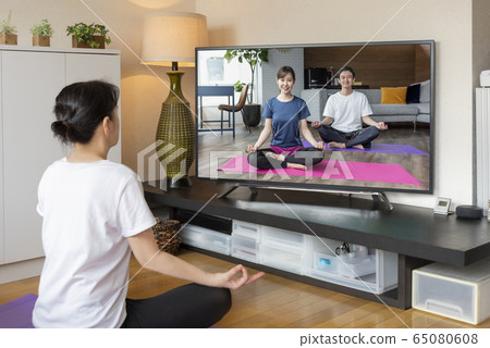 Webinar Online yoga seminar Woman doing yoga while watching DVD Webinar Online yoga seminar Woman doing yoga while watching DVD 65080608