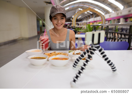 Young beautiful woman vlogging with mobile phone in restaurant 65080807