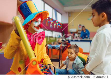 Clown with joyful children play in the alphabet 65080881