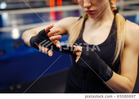 Woman winds up black bandages, boxing training Woman winds up black bandages, boxing training 65080897