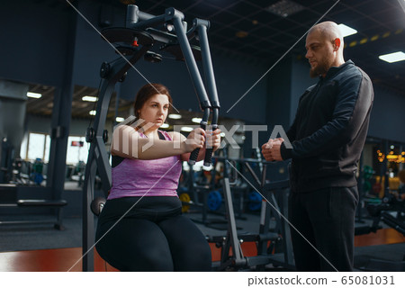 Overweight woman doing exercise in gym Overweight woman doing exercise in gym 65081031