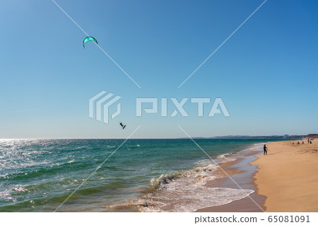 The athlete practices kate board surfing the sea on the waves. Summer in Portugal Algarve. The athlete practices kate board surfing the sea on the waves. Summer in Portugal Algarve. 65081091