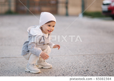 Cute little gilr play with little dor outside. Yorkshire terrer play and jump. Adorable gilr have fun with pet 65081564