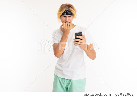 Beautiful young man with mobile phone isolated on white background Beautiful young man with mobile phone isolated on white background 65082062