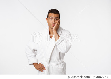 African American guy wearing a bathrobe with happy emotion. Isolated over whtie background. 65082237