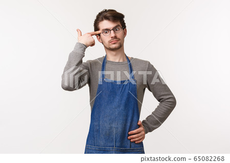 Portrait of annoyed and tensed young caucasian male employee, cafe worker make pistol sign near temple as if blowing his mind with gun as hear something stupid and riddiculous, white background 65082268