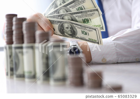 Man holds in his hand fan dollars, investment Man holds in his hand fan dollars, investment 65083329