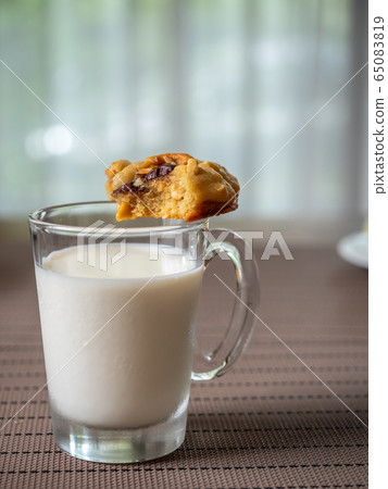 Chewy chocolate chip soft cookie on cup of milk 65083819