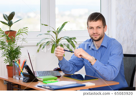 Portrait of an office specialist at a desk in an Portrait of an office specialist at a desk in an 65083920
