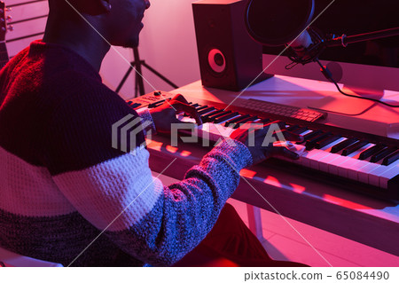 Professional african american musician recording synthesizer in digital studio at home, close-up. Music production technology concept. Professional african american musician recording synthesizer in digital studio at home, close-up. Music production technology concept. 65084490