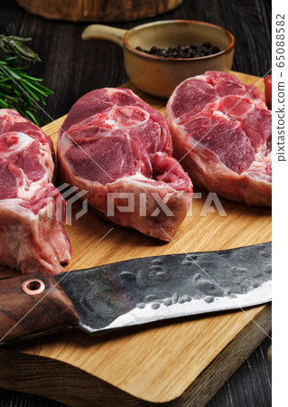 Close up view of raw fresh lamb shank on cutting board with spice Close up view of raw fresh lamb shank on cutting board with spice 65088582