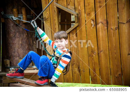 Boy climbing up into a treehouse. Healthy games Boy climbing up into a treehouse. Healthy games 65088905