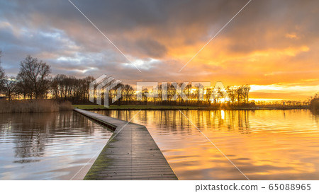 Wooden walkway in lake under orange sunset Wooden walkway in lake under orange sunset 65088965