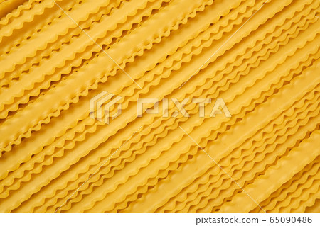 dry mafaldine pasta on a cane tablecloth 65090486