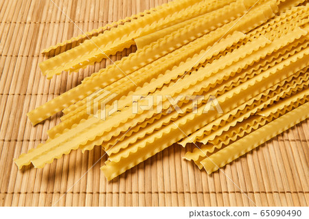 dry mafaldine pasta on a cane tablecloth dry mafaldine pasta on a cane tablecloth 65090490