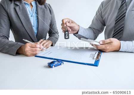 Car rent agent manager holding key of new car Car rent agent manager holding key of new car 65090613