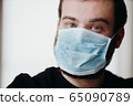 Portrait of man wearing a protective medical face mask to prevent infection of coronavirus. 65090789
