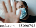 Coronavirus. Sick man of corona virus looking through the window and wearing mask protection. 65090798