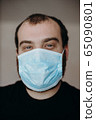 Portrait of man wearing a protective medical face mask to prevent infection of coronavirus. 65090801
