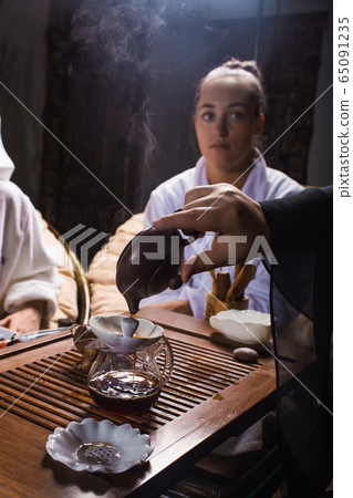 Tea ceremony after the sauna. Girls in white coats drink Chinese tea. Tea ceremony after the sauna. Girls in white coats drink Chinese tea. 65091235