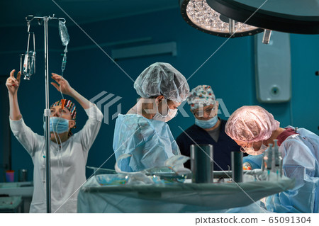 Group of surgeons in operating theater. Medical team performing surgery in operation room. Group of surgeons in operating theater. Medical team performing surgery in operation room. 65091304