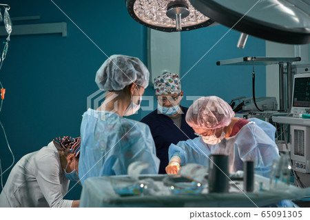 Group of surgeons in operating theater. Medical team performing surgery in operation room. 65091305