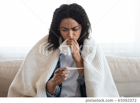 Coronavirus Symptoms. Sick black woman checking her body temperature at home 65092072