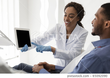 Dentist doctor pointing at empty digital tablet screen 65092090