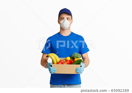 Delivery during coronavirus. Courier with box of vegetables 65092289