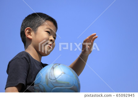 Elementary school student holding a soccer ball (5th grader) and blue sky Elementary school student holding a soccer ball (5th grader) and blue sky 65092945