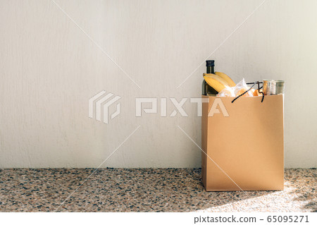 Paper bag with food on the floor next to the wall of house. Paper bag with food on the floor next to the wall of house. 65095271