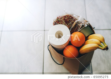 Paper bag with food and toilet paper on the floor at the entrance to house. Paper bag with food and toilet paper on the floor at the entrance to house. 65095273