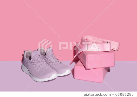 New purple sneakers, pink yogs blocks and strap on colorful background with copy space. 65095293