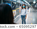 Two young asian women friends wearing protective mask meet in a subway station with bare hands.  65095297