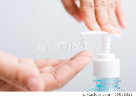 Close up woman applying press dispenser sanitizer 65096321